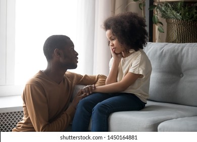 Loving African American Father Talk With Upset Preschooler Daughter Helping With Problem, Caring Black Young Dad Speak With Sad Girl Child Holding Caressing Hand, Show Support And Understanding