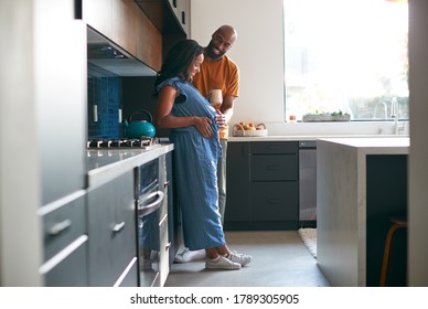 Loving African American Husband With Pregnant Wife At Home In Kitchen Together - Powered by Shutterstock