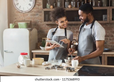 Loving african-american couple baking and using digital tablet in loft interior. - Powered by Shutterstock