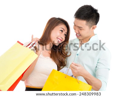 Loving Asian couple with paper bags looking at each other