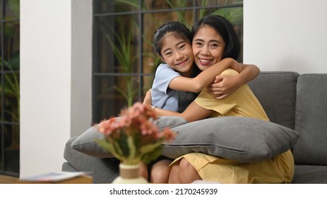 Loving Asian Mom Cuddling Her Sweet Daughter. Life Insurance, Love And Support In Family Relationships Concept