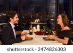 Loving beautiful young couple in a restaurant celebrating anniversary. Romantic dinner on Valentine day concept