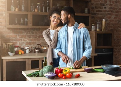 Loving Black Couple Preparing Salad In Loft Kitchen At Home