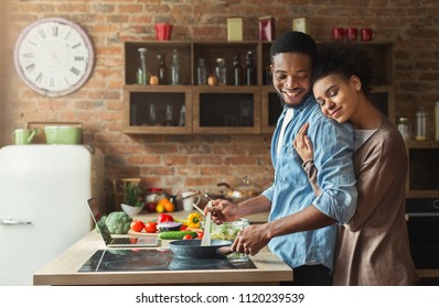 Loving Black Wife And Husband Preparing Dinner. Happy Family Cooking Vegetarian Food In Loft Kitchen