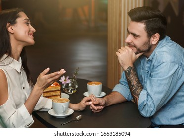 Loving Boyfriend And Girlfriend Dating Talking And Having Coffee Drinks In Cafeteria. Romance And Love