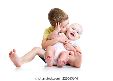 Loving brother kissing his little sister isolated on white