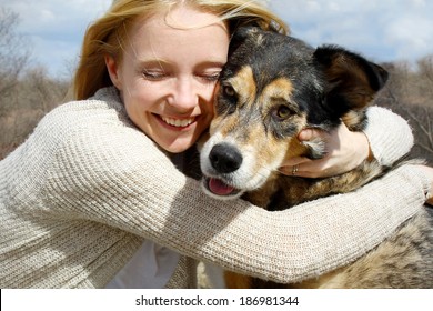 A Loving And Candid Portrait Of A Happy Woman Hugging Her Large German Shepherd Dog.