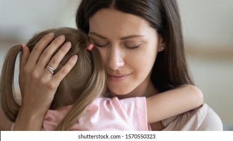 Loving Caring Adult Woman Foster Parent Mom Holding Little Kid Daughter Giving Comfort, Protection And Support Concept, Young Tender Single Mother Hugging Adopted Small Child Feeling Love Cuddling