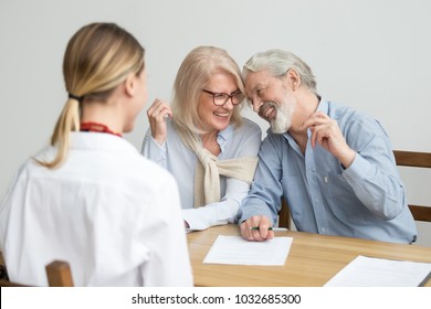 Loving Caring Senior Aged Couple Laughing Signing Documents At Meeting With Financial Advisor, Happy Older Retired Family Investing Savings In Bank, Making Real Estate Deal, Buying Medical Insurance