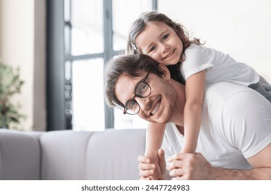 Loving cheerful young father with his small kid daughter girl having fun together, spending time, celebrating father`s day. I love you, dad! Parenthood, fatherhood concept - Powered by Shutterstock