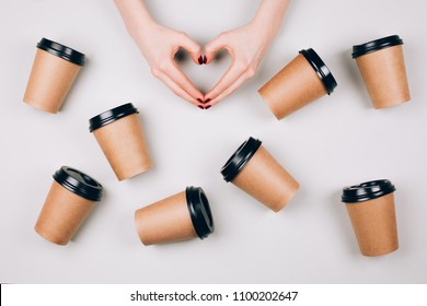 Loving Coffee Concept. Two Hands Making Heart Between Many Paper Cups Of Coffee To Go