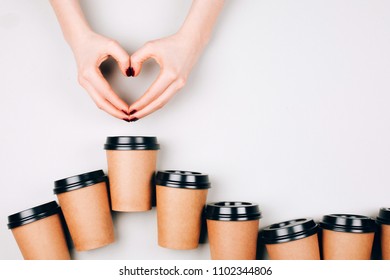 Loving Coffee Concept. Two Hands Making Heart Between Many Paper Cups Of Coffee To Go