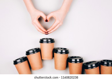 Loving Coffee Concept. Two Hands Making Heart Between Many Paper Cups Of Coffee To Go