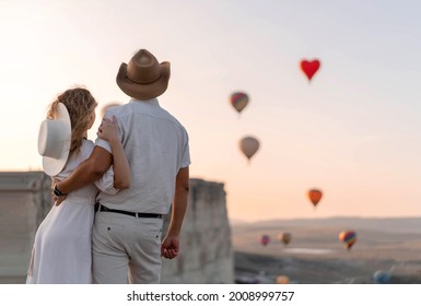 A loving couple among the balloons. A couple in love in Cappadocia. Couple in Turkey. Honeymoon in the mountains. The man and the woman are traveling. Hot air balloon flights. Wedding. Journey. Love