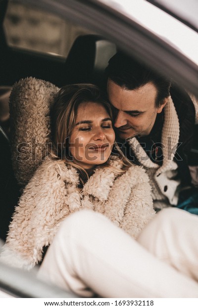 Loving couple in a car in the winter forest, NOISE\
EFFECT ON PHOTOS