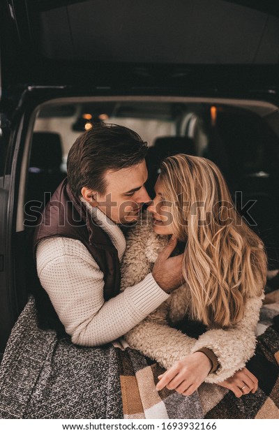 Loving couple in a car in the winter forest, NOISE\
EFFECT ON PHOTOS