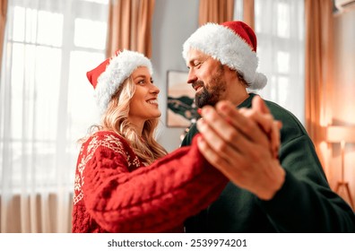 Loving couple dances together, celebrating the New Year and Christmas. They share delightful moments,creating cherished memories as they enjoy each other’s company in a warm and festive atmosphere.    - Powered by Shutterstock