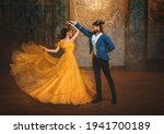 loving couple is dancing at fairy ball. Happy beauty woman fantasy princess in yellow dress and guy is enchanted beast, horns on head Girl whirls in arms of male prince. Man monster carnival costume.