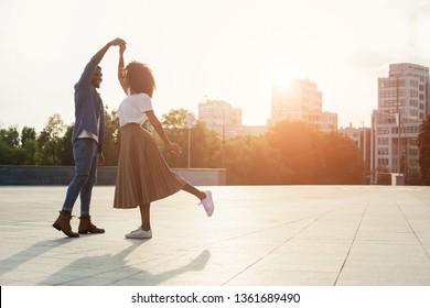 Loving couple dancing at sunset walking in city, copy space