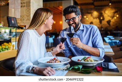 Loving couple enjoying lunch in the restaurant, eating paste and drinking red wine. Lifestyle, love, relationships, food concept - Shutterstock ID 2046991322
