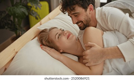 A loving couple enjoys an intimate moment together, lying in a cozy bedroom setting, reflecting affection and comfort. - Powered by Shutterstock