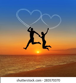 Loving Couple Flying At Sky Against Sea Beach And Heart Shaped Vapour Trail - Happy Valentines Day Concept