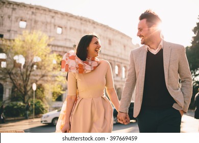 Loving Couple In Front Of The Colosseum In Rome