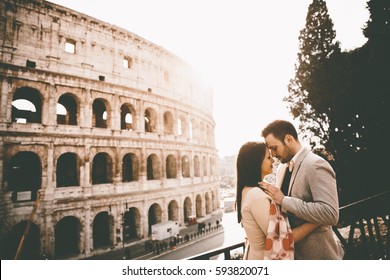 Loving Couple In Front Of The Colosseum In Rome, Italy
