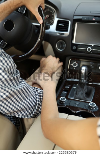 Loving couple\
holding hands in car\
close-up