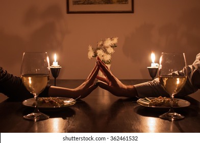 Loving couple holding hands during romantic dinner