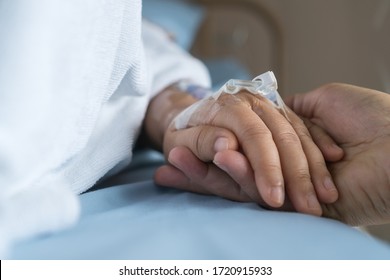 Liebende Ehepaare, die Händchen halten, Hoffentlich, Pflege Liebe emotionale Konzept, Zusammen halten Frauen Hand Liebhaber, während Sick Patienten mit Infusionspumpe Flüssigkeit. Ermutigung zur beruhigenden Erholung von der Familie