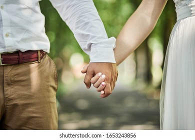 Loving Couple Holding Hands Walking In Park