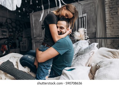  Loving couple hug each other on the bed, in big bedroom. Love story, side view - Shutterstock ID 590708636
