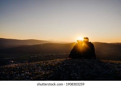 Loving couple kissing at sunset, having a romantic picnic date.Boyfriend and girlfriend in love, showing affection in nature. A romantic gesture, intimate moment.Sunset nature view.Expressing emotion