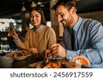 A loving couple laughing while eating in the restaurant afterwork