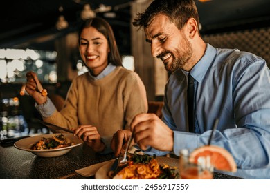 A loving couple laughing while eating in the restaurant afterwork - Powered by Shutterstock