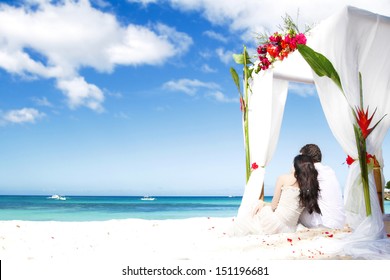 Loving Couple On Wedding Day Near Bamboo Arch With Flowers On Tropical Sea Background