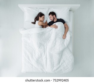 Loving couple relaxing and sleeping in bed, top view