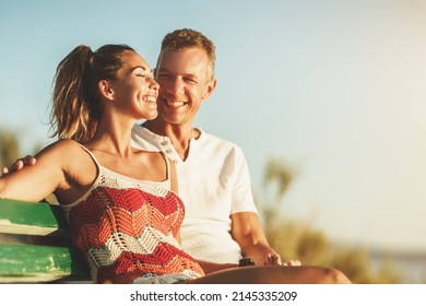 A loving couple are sitting on bench and enjoying a summer vacation near the sea beach.