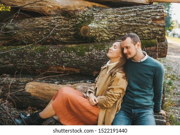 Loving couple sitting on the felled logs in the forest. Man and woman embracing. love story. Closeup - Powered by Shutterstock