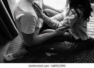 Loving Couple Sitting On The Floor At Home And Cuddling. Relationship, Love Concept.