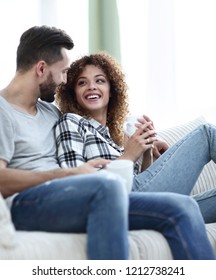 loving couple sitting on a sofa in the living room - Shutterstock ID 1212738241
