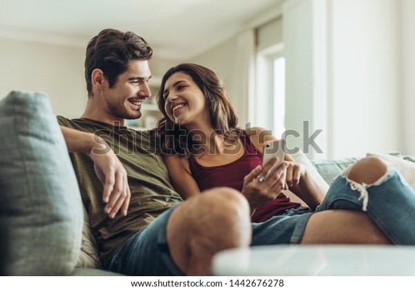 loving-couple-sitting-on-sofa-600w-1442676278.jpg
