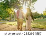 A Loving Couple Strolling Hand in Hand Through a Sunlit and Beautiful Park Together