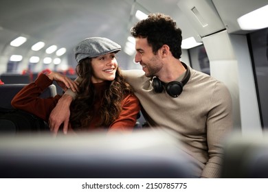 Loving Couple Travel By Train. Happy Woman And Man Talking While Sitting In The Train.