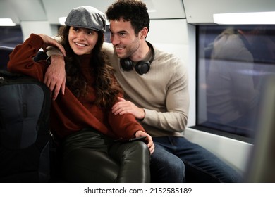 Loving couple travel by train. Happy woman and man talking while sitting in the train.