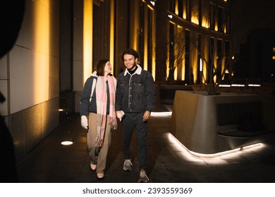 loving couple in winter clothes walks the city in the evening, happy young people in cold weather. - Powered by Shutterstock