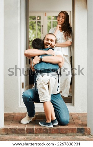 Loving dad hug and embrace son, love from father to son or parents saying goodbye to child on front porch at home. Happy family greeting little boy with mother standing in doorway or house entrance.