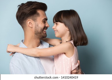 Loving daddy look at little adorable daughter feeling love isolated on blue studio background profile faces side view, deep devotion warm relationships, love care, closest person, fathers day concept