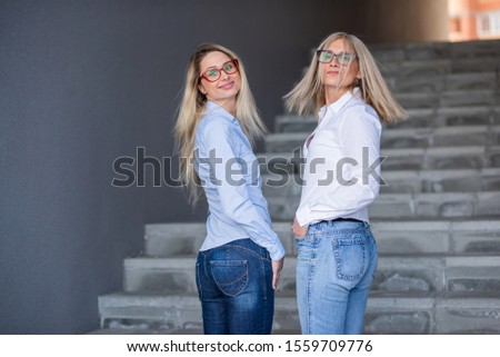 Similar – Image, Stock Photo Twin sisters stand laughing back to back in front of a stone wall